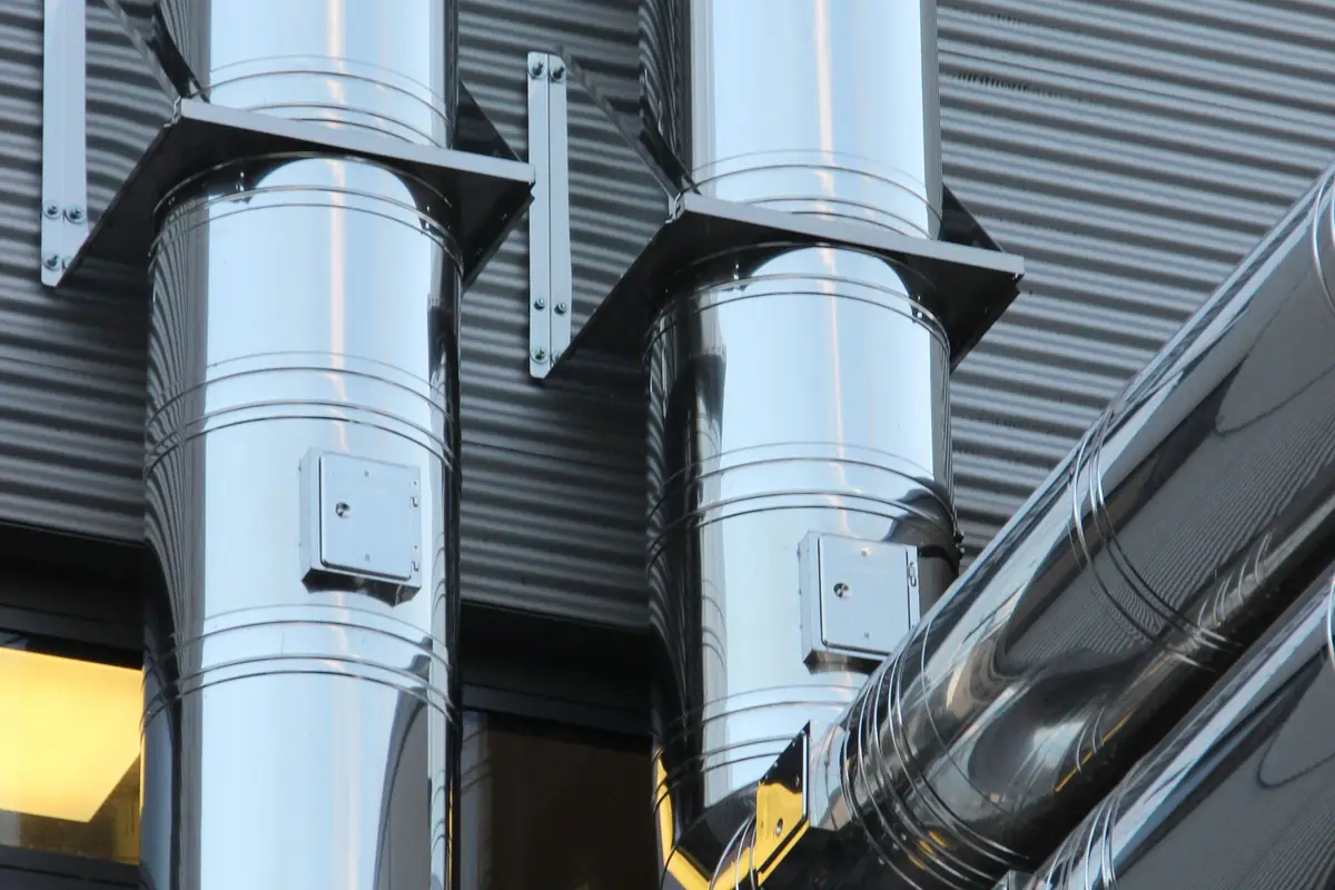 Insulated ventilation ducts running up the technical facade of a building.